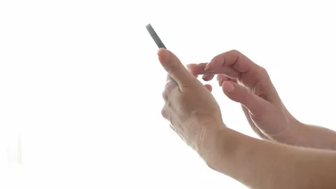 Woman using a smartphone in front of a window brightly lit by daylight Stock Footage 280534895