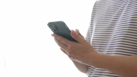 Woman using a smartphone in front of a window brightly lit by daylight Stock Footage 280534920