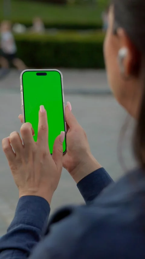 Woman Using Smartphone with Green Screen Mock-up On City Park. Vertical Video Stock Footage 341865216