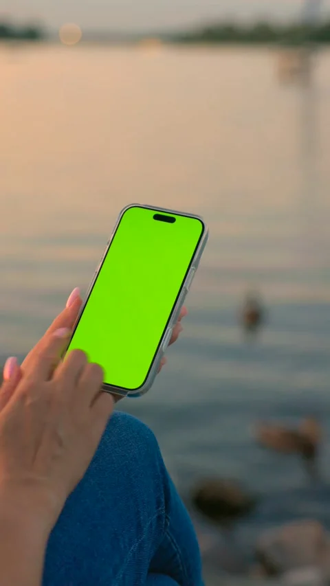 Woman Using Smartphone with Green Screen Against of River on City Waterfront Stock Footage 341865223