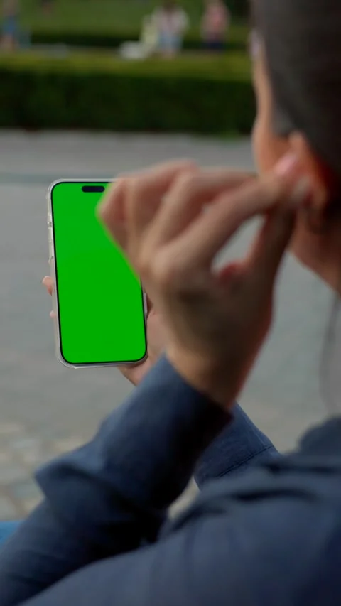 Woman Using Smartphone with Green Screen Mock-up On City Park. Vertical Video Stock Footage 341865229