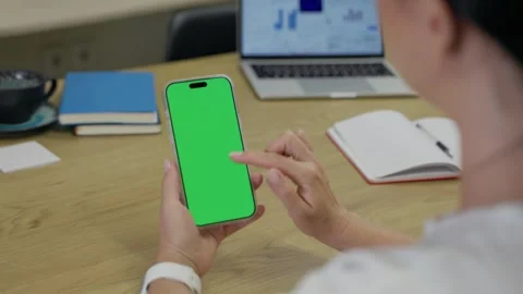 Woman Using Smartphone with Green Screen Chroma Key at Her Desk in Office Stock Footage 341865568