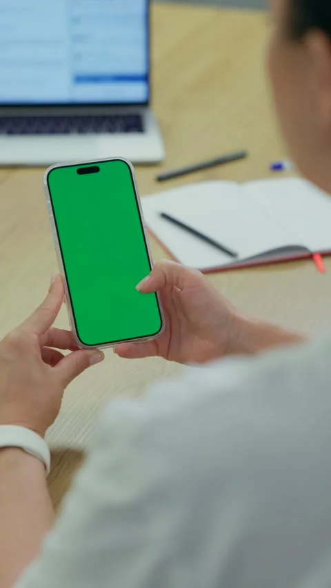 Woman Using Smartphone with Green Screen Chroma Key at Her Desk in Office Stock Footage 341866083