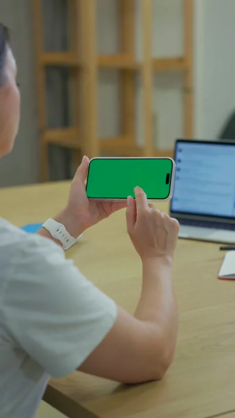 Woman Using Smartphone with Green Screen Chroma Key at Her Desk in Office Stock Footage 341866106
