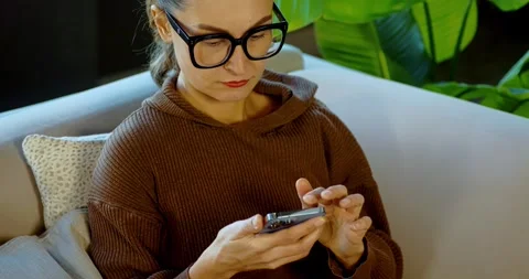 Woman using smartphone at home Stock Footage 324581440