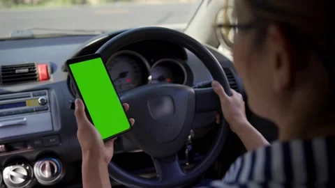 Woman using a smartphone inside the car. Chromakey smartphone with green screen. Stock Footage 170589221