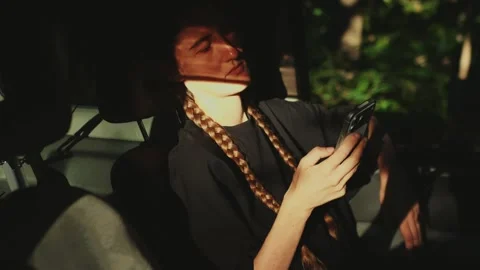 Woman using smartphone inside a sunlit car, representing mobile... Stock Footage 341613056