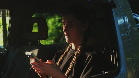 Woman using smartphone inside SUV, representing mobile automotive... Stock Footage 341613108