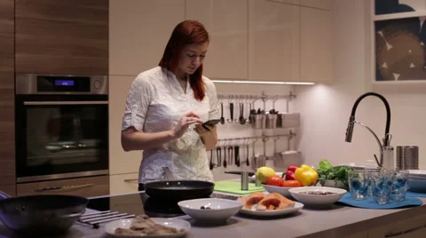 Woman using smartphone in the kitchen Video stock 58086490