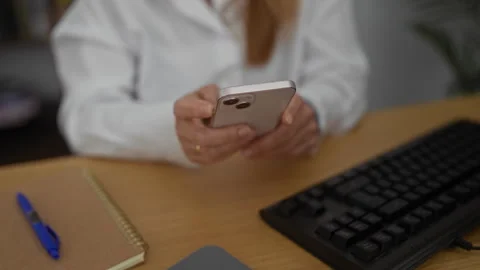 Woman using smartphone at office desk with keyboard notepad pen and hands v.. Stock Footage 281807341