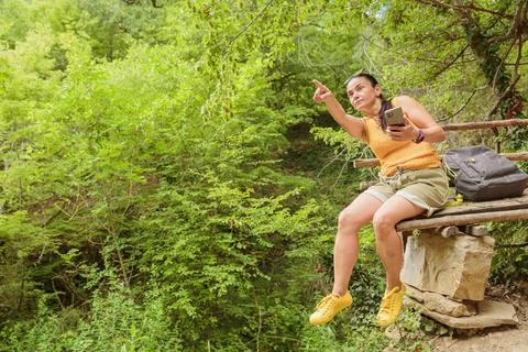 Woman using smartphone for pathfinding in forest Stock Photos