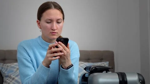 A woman using a smartphone, planning trips, Vidéo 307322502