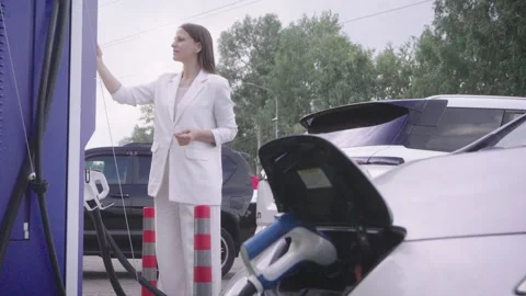 Woman Using Smartphone at Public EV Charging Station, Eco Friendly Transpor.. Stock Footage 339766968