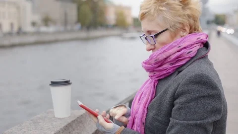 Woman using smartphone at river Stock Footage