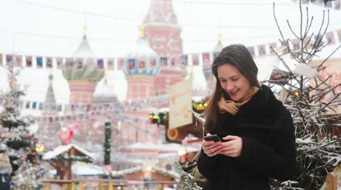 Woman using a smartphone standing in the winter on the Red Square in Moscow, in Stock Footage 67365219
