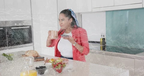 Woman using smartphone tech in kitchen sipping copper mug among breakfast Video stock 315746160