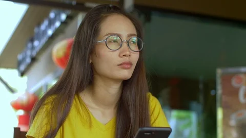 Woman Using Smartphone Touchscreen In Cafe. Asian Women Watching And Using Cell  Stock Footage 106799785
