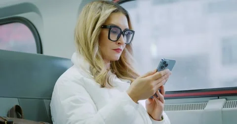 Woman Using Smartphone on a Train Journey Stock Footage 323452085