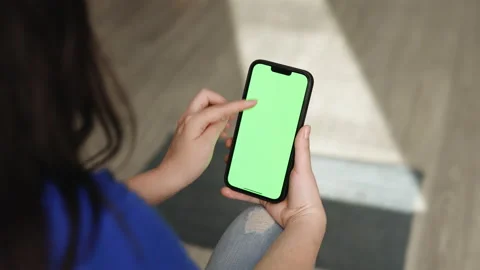 Woman Using Smartphone in Vertical Mode with Green Mock-up Screen, Doing Stock Footage 194808072