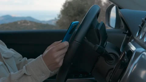 Woman using smartphone while driving modern car Stockbeeldmateriaal 316293314