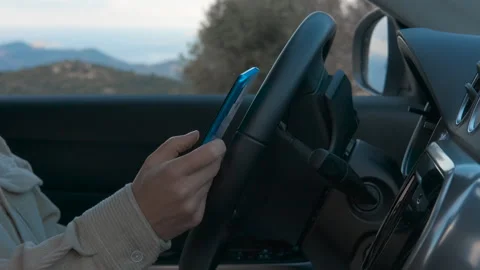 Woman using smartphone while driving modern car Stockbeeldmateriaal 319915007