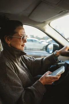 Woman Using Smartphone While Driving in Traffic Stock Photos