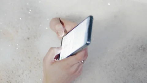 Woman Using Smartphone While Having Bath, Close Up Stock Footage 99980423