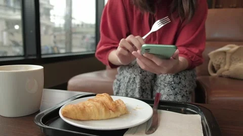 Woman using smartphone while having breakfast in coffee shop. Stock Footage 134642772