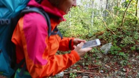 Woman using smartphone while hiking on trek with backpack in nature. Stock Footage 82663987