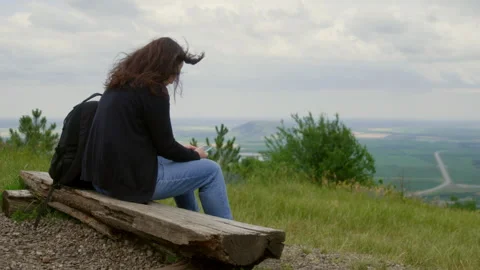Woman using smartphone while relaxing on hill against sky Video stock 291501315