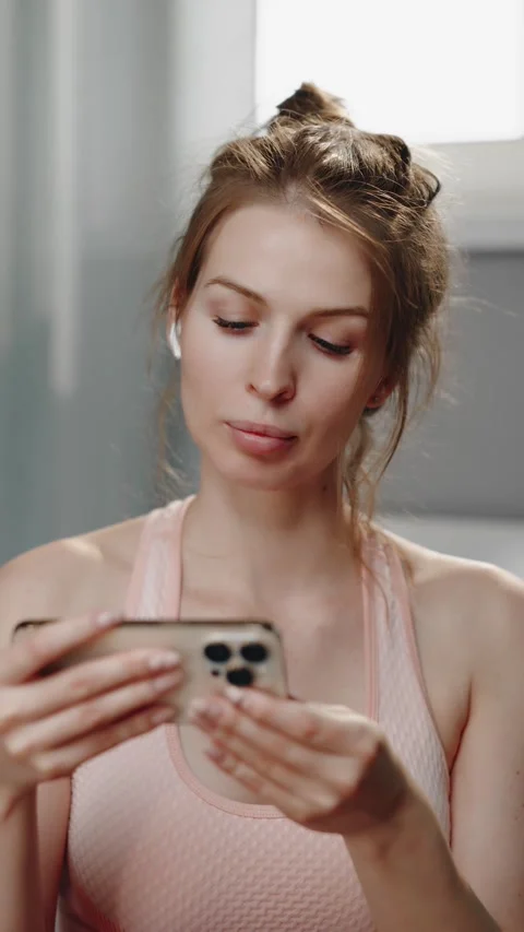 Woman using smartphone while resting after workout Vídeos de archivo 319443020