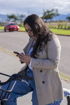 Woman using smartphone while resting on bicycle 스톡 사진