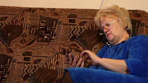 Woman is using a smartphone while sitting on the couch Stock-Footage 73447473