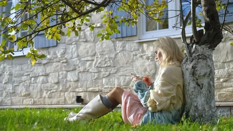 Woman using smartphone while sitting in the garden near the house Stock Footage 200826538