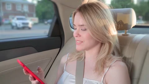 Woman using smartphone while sitting in the back seat of a car Stock Footage 276815823