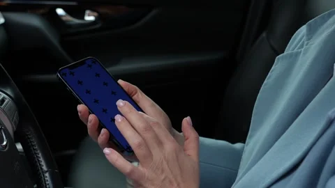 Woman using a smartphone while sitting behind the wheel of a car Stock Footage 280534836
