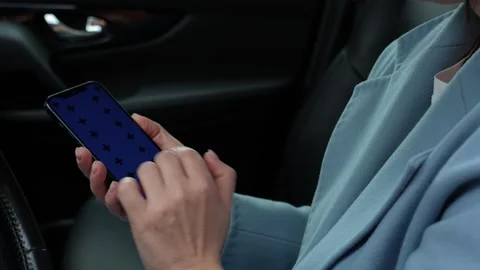 Woman using a smartphone while sitting behind the wheel of a car Stock Footage 280534849