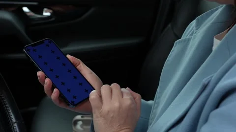 Woman using a smartphone while sitting behind the wheel of a car Stock Footage 280534887