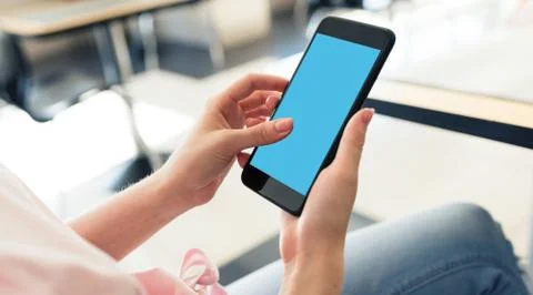 Woman using smartphone while sitting at a cafe Stock Photos
