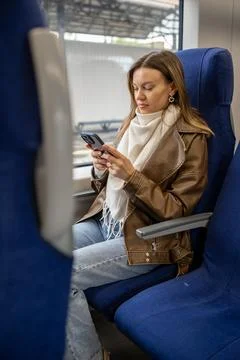 Woman Using Smartphone While Sitting in Train Seat on a Journey Stock Photos