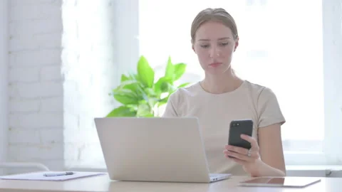 Woman using Smartphone while using Laptop Stock Footage 205001310