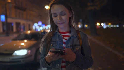 Woman using smartphone while walking through the streets of the evening city Stock Footage 119889509