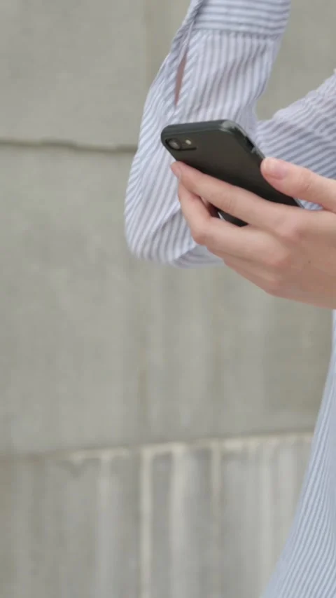 Woman using Smartphone while Walking in Street, Vertical Video 스톡 동영상 339669784