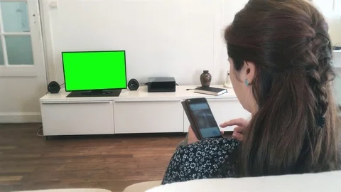 Woman Using Smartphone While Watching Tv, Green Screen Footage Stock Footage 82420862
