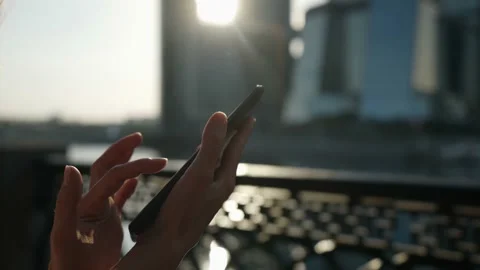Woman is using smartphone with wireless internet outdoors on city street at Stockbeeldmateriaal 159143494