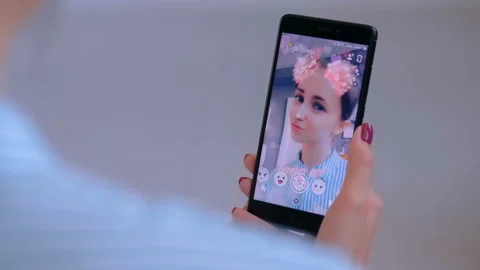 Woman using Snapchat multimedia messaging app with face mask on smartphone Stock Footage 109201533