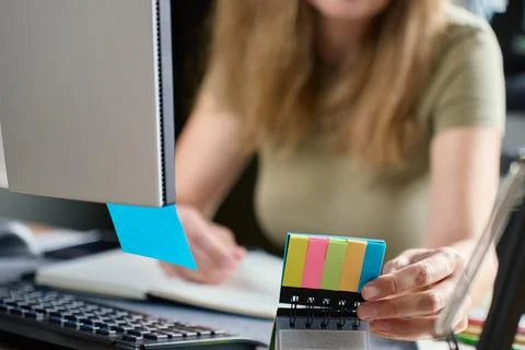 Woman using sticky notes while planning work at home office desk 스톡 사진