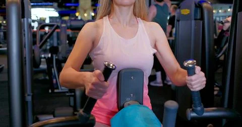 Woman Using Strength Training Machine at Gym 库存照片