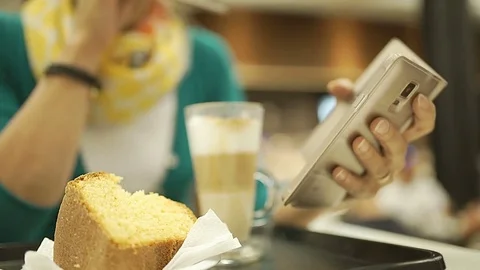 Woman using stylus while browsing internet on smartphone in the cafe, steadycam Stock Footage