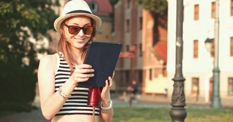 Woman using tablet and drinking coffee in the sunny European city. Slow Motion. Vidéo 53462775